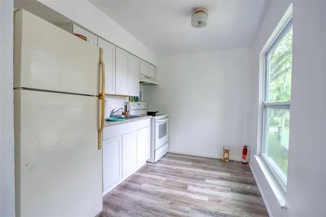 a kitchen with a refrigerator and a stove