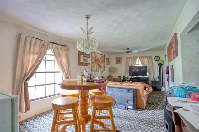 a dining room with furniture a chandelier and window