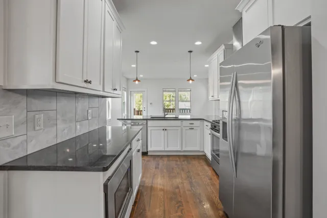 a kitchen with a refrigerator a sink and cabinets