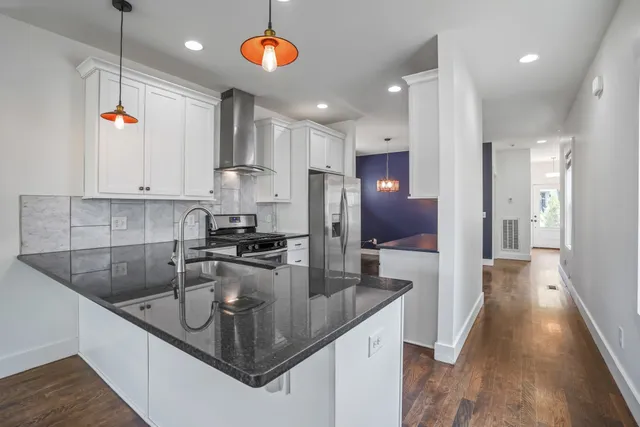 a kitchen with stainless steel appliances granite countertop a sink a refrigerator and a stove