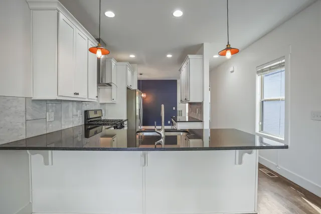 a kitchen with stainless steel appliances granite countertop a sink a refrigerator and a granite counter tops