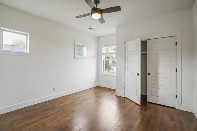 a view of empty room with wooden floor