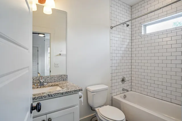 a bathroom with a granite countertop toilet a sink and bathtub