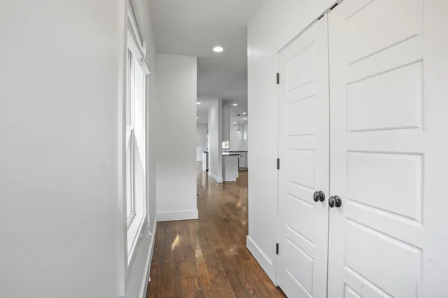 a view of a hallway with wooden floor and staircase