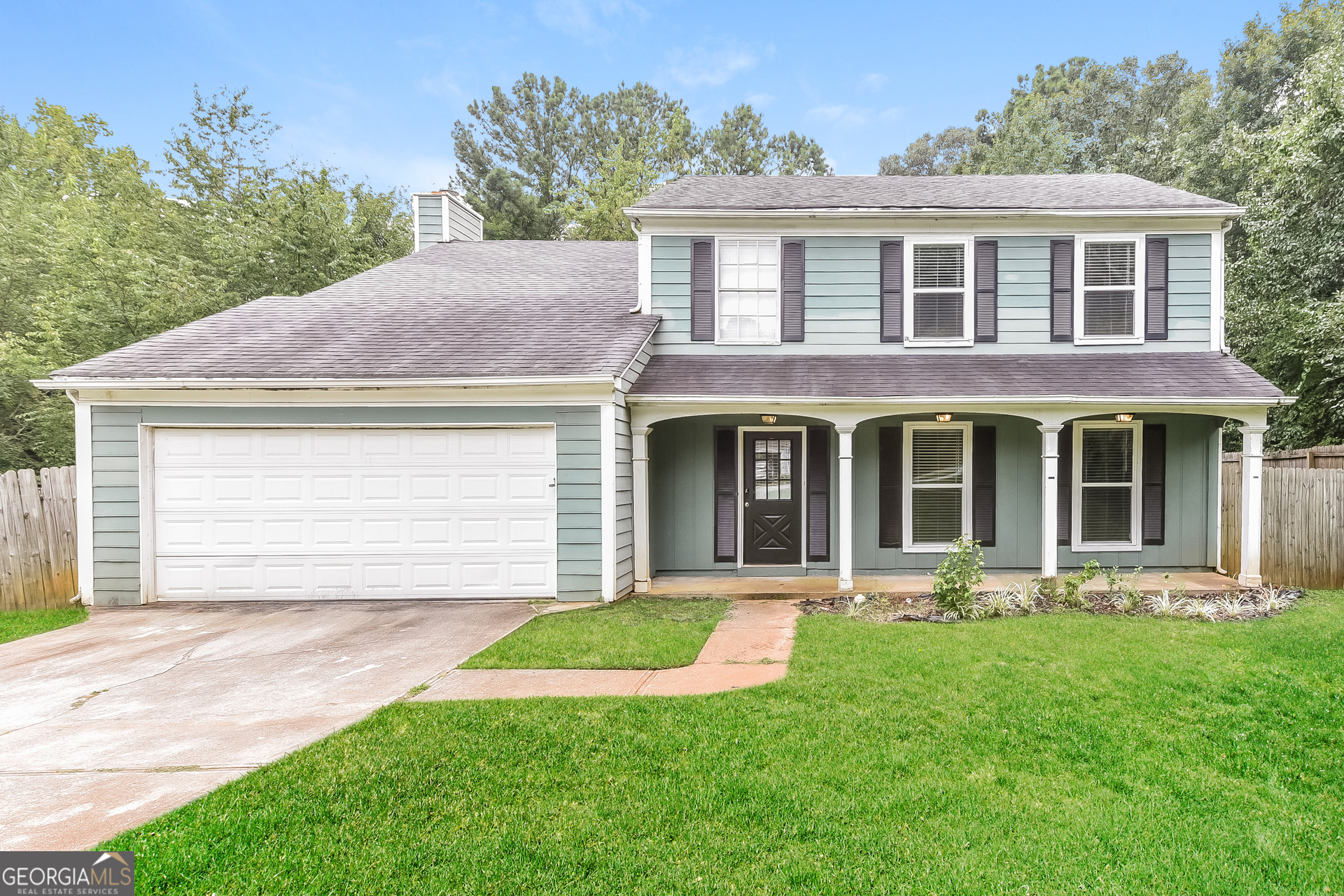 a front view of a house with garden and porch