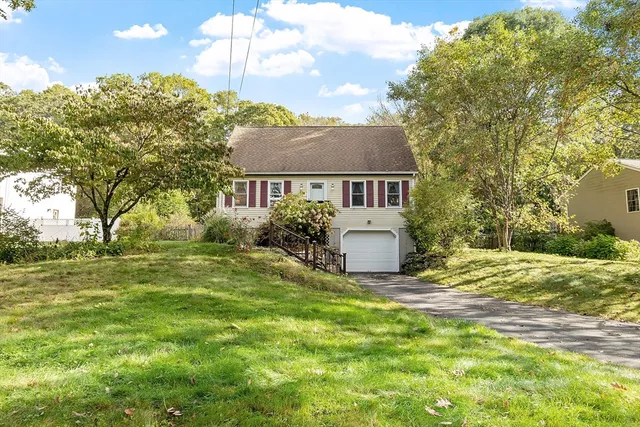a view of a house with a big yard and large trees