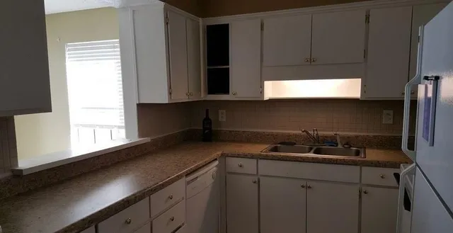 a kitchen with a sink a cabinets and window