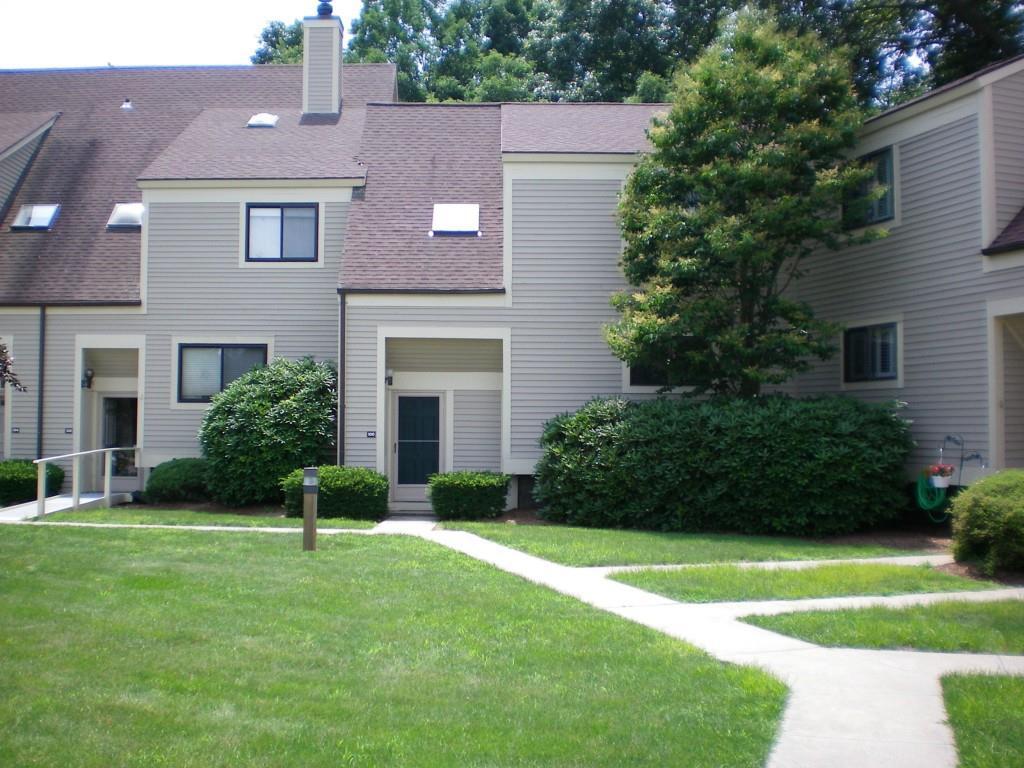 100 Sandy Point Road, Unit 100 Old Saybrook, CT 06475 - Photo 1 of 1 a front view of a house with a yard and plants