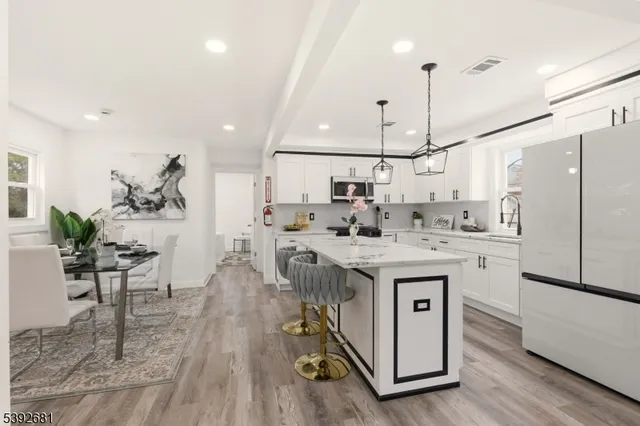 a kitchen with kitchen island a white cabinets and wooden floor