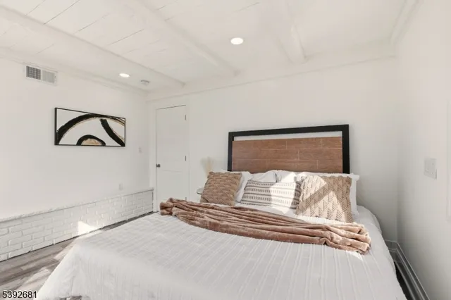 a bedroom with a bed and painting on the wall