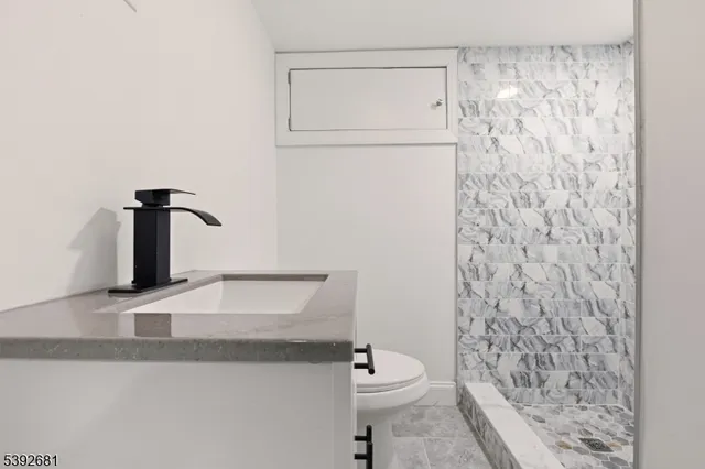a bathroom with a granite countertop sink toilet and a mirror