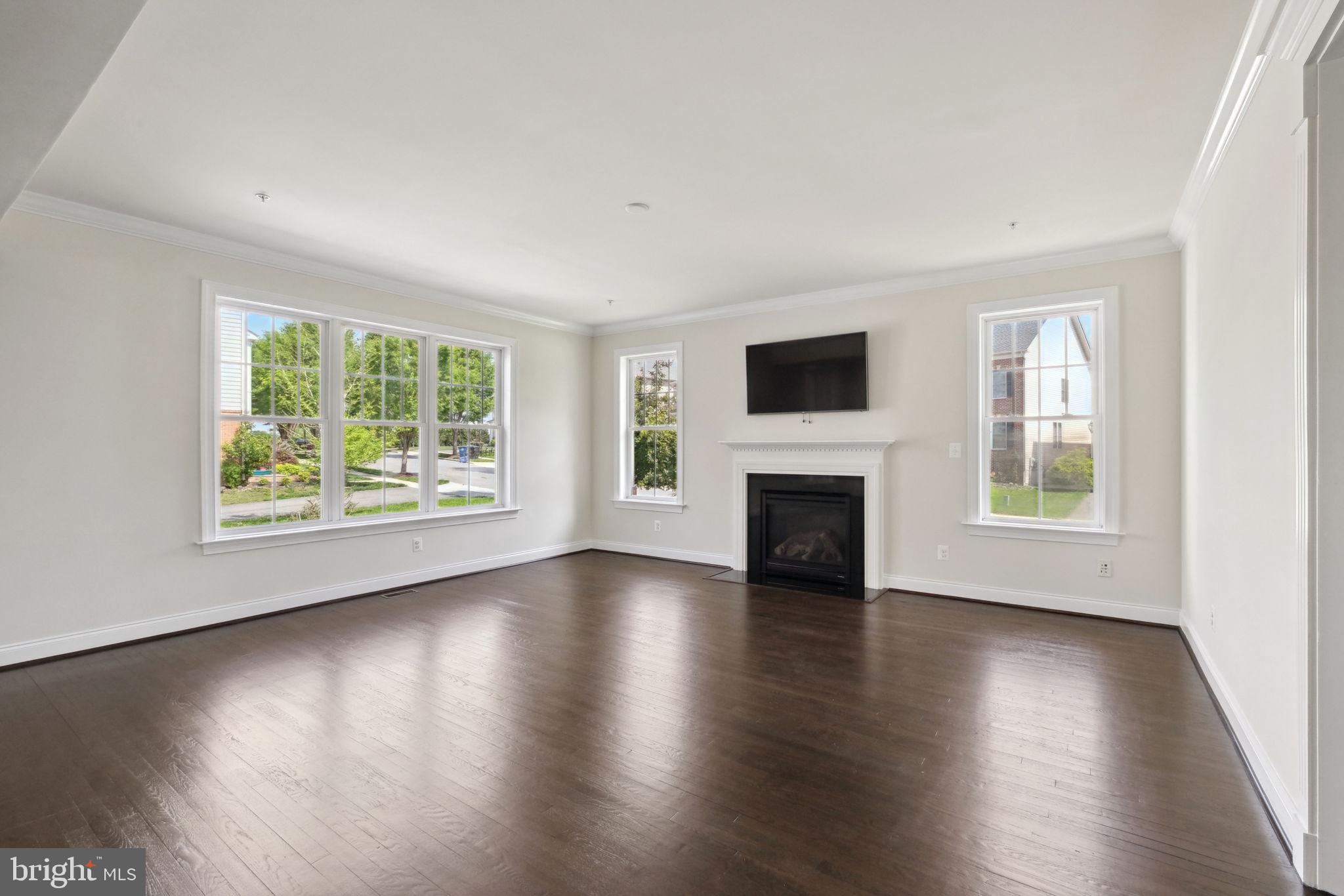 13501 Moonlight Trail Drive Silver Spring, MD 20906 - Photo 10 of 77 an empty room with wooden floor a fireplace and windows
