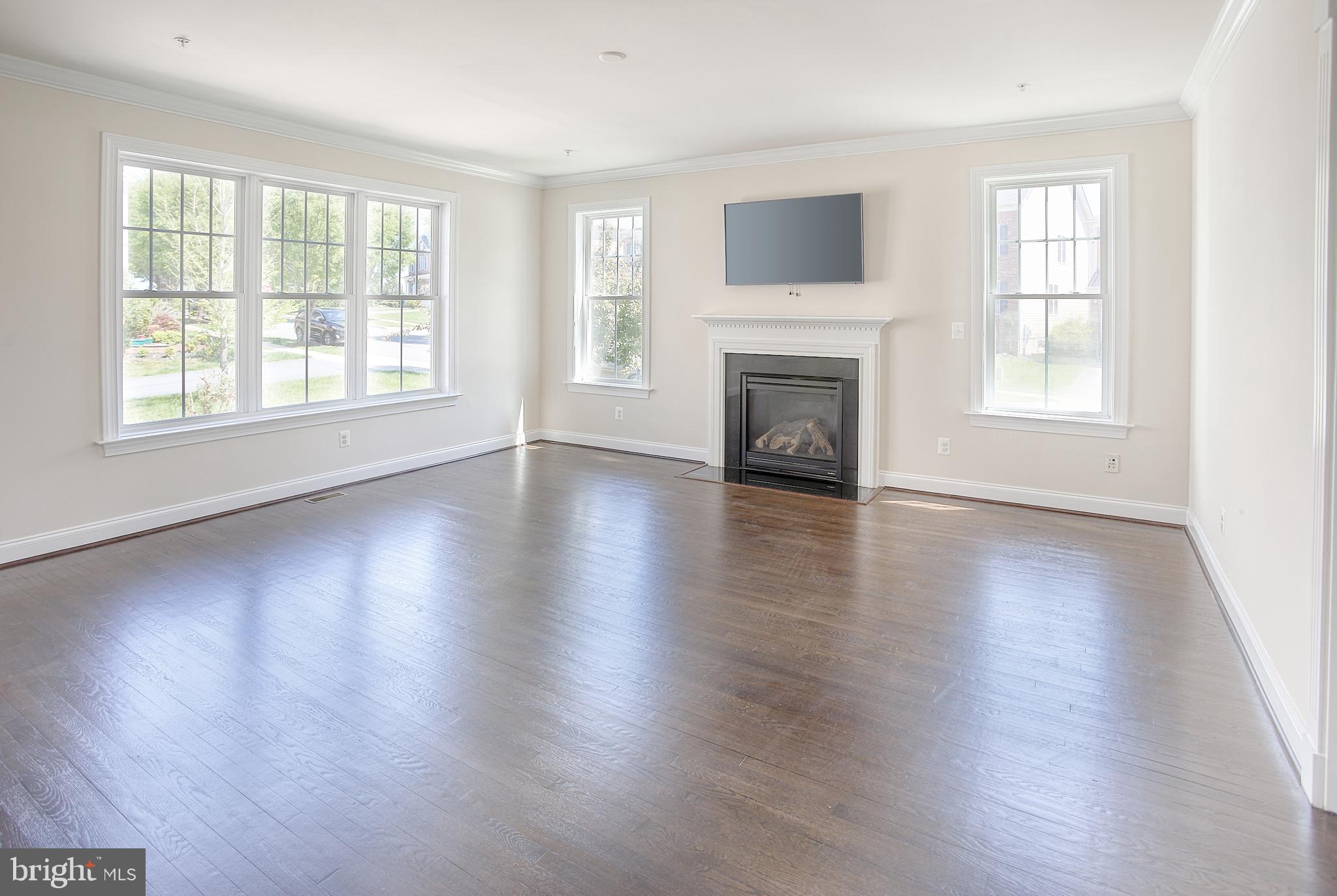 13501 Moonlight Trail Drive Silver Spring, MD 20906 - Photo 15 of 77 an empty room with wooden floor fireplace and windows