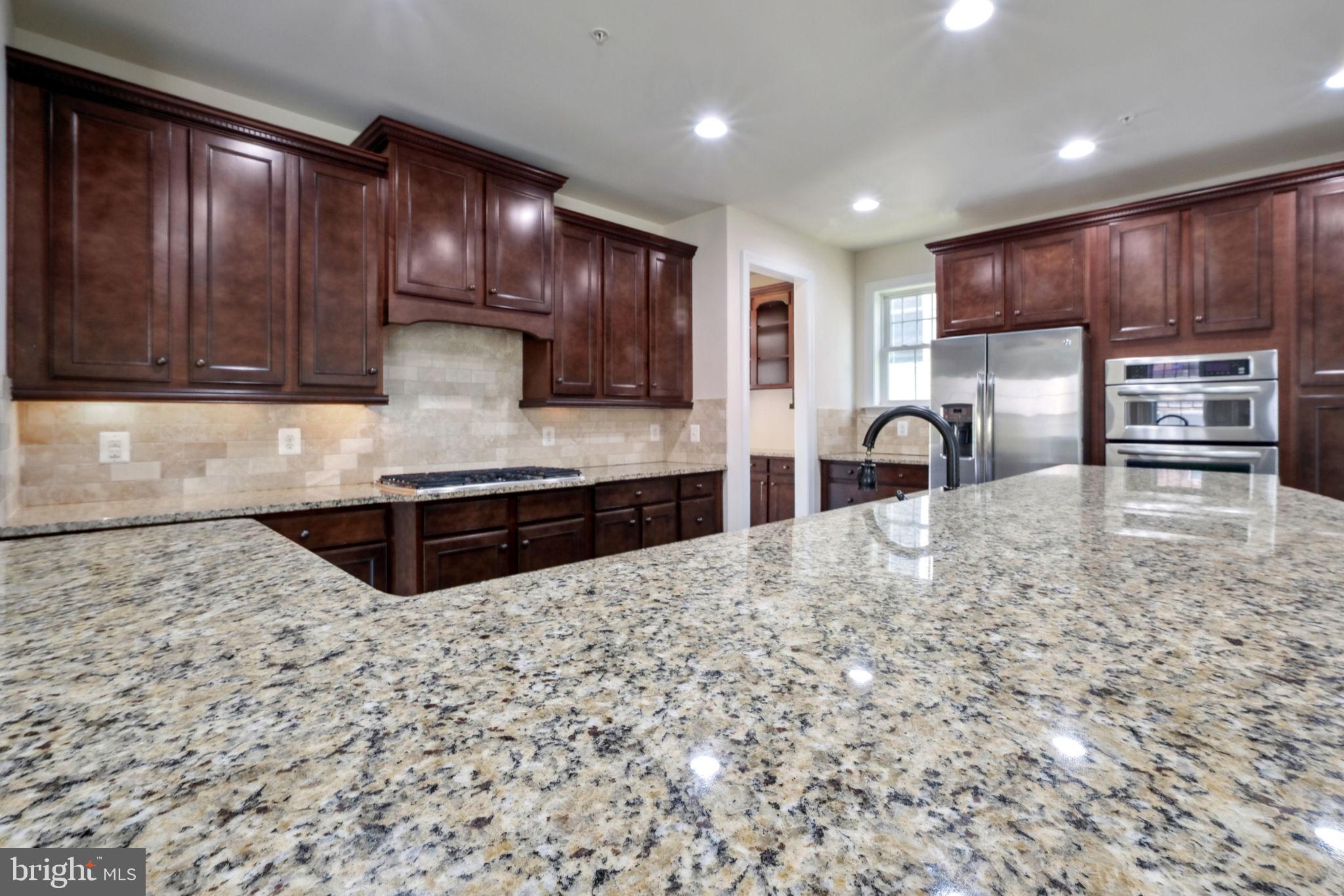 13501 Moonlight Trail Drive Silver Spring, MD 20906 - Photo 17 of 77 a kitchen with stainless steel appliances granite countertop a stove a sink and a microwave