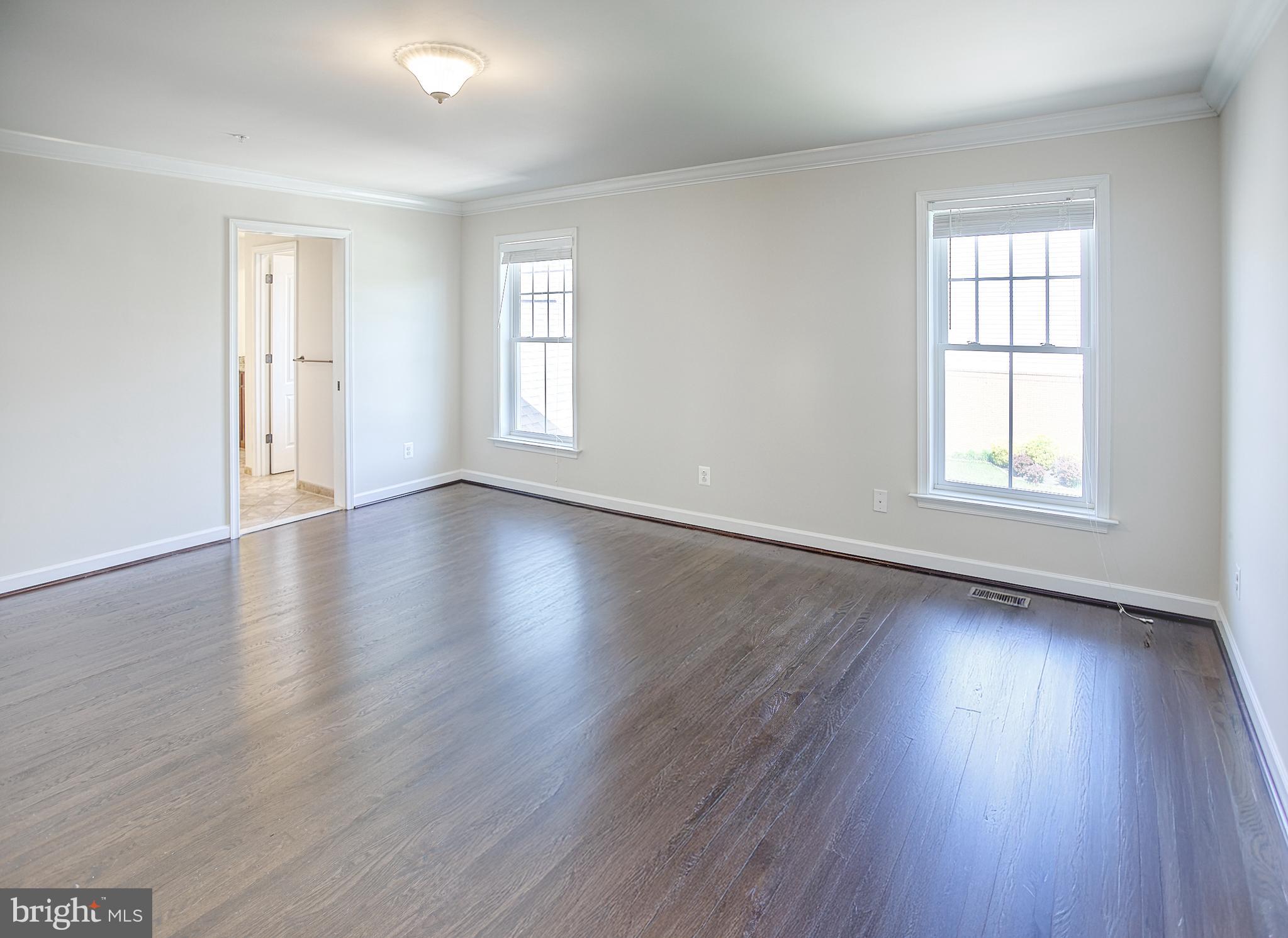 13501 Moonlight Trail Drive Silver Spring, MD 20906 - Photo 36 of 77 an empty room with wooden floor and windows