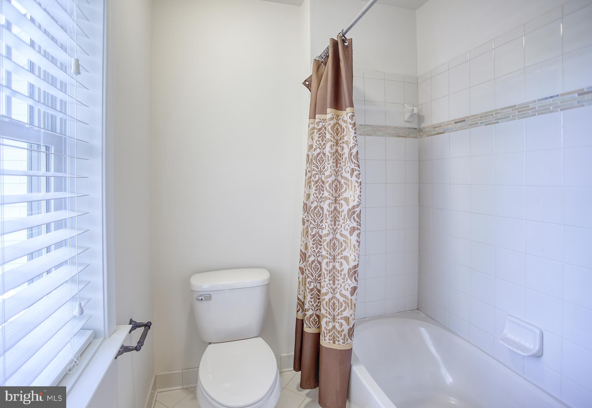 13501 Moonlight Trail Drive Silver Spring, MD 20906 - Photo 49 of 77 a white toilet sitting next to a shower curtain