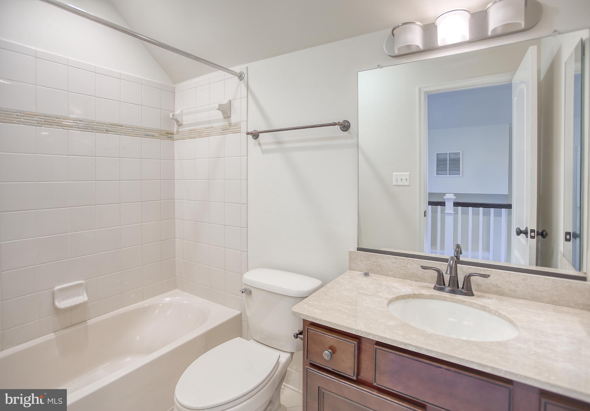 13501 Moonlight Trail Drive Silver Spring, MD 20906 - Photo 54 of 77 a bathroom with a granite countertop sink toilet a mirror and shower