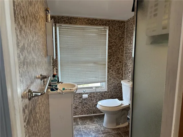 a bathroom with a toilet a sink and mirror
