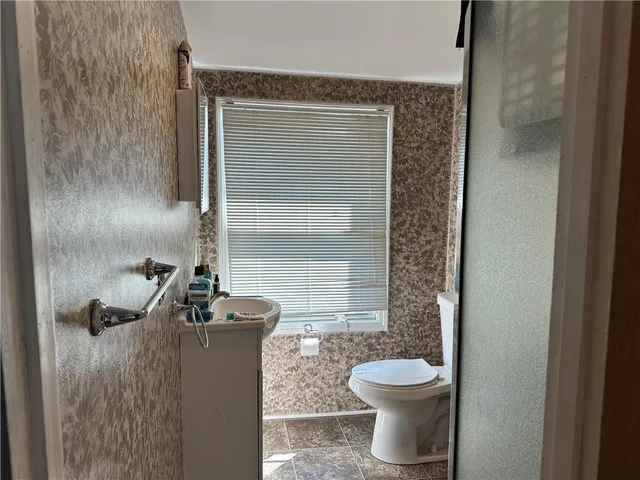 a bathroom with a toilet and a shower