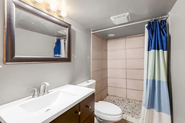 a bathroom with a sink a toilet and shower