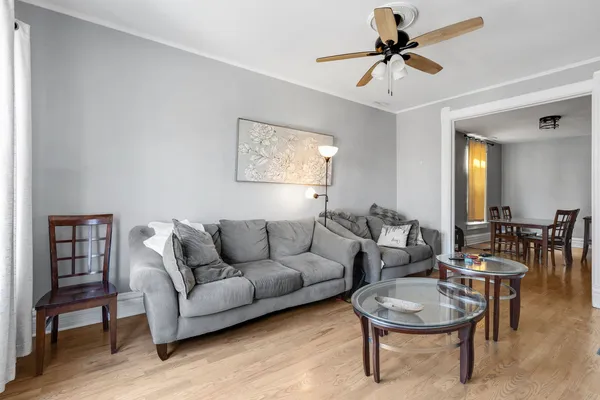 a living room with furniture a rug and a ceiling fan