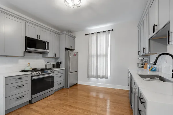 a kitchen with stainless steel appliances a stove microwave and a refrigerator