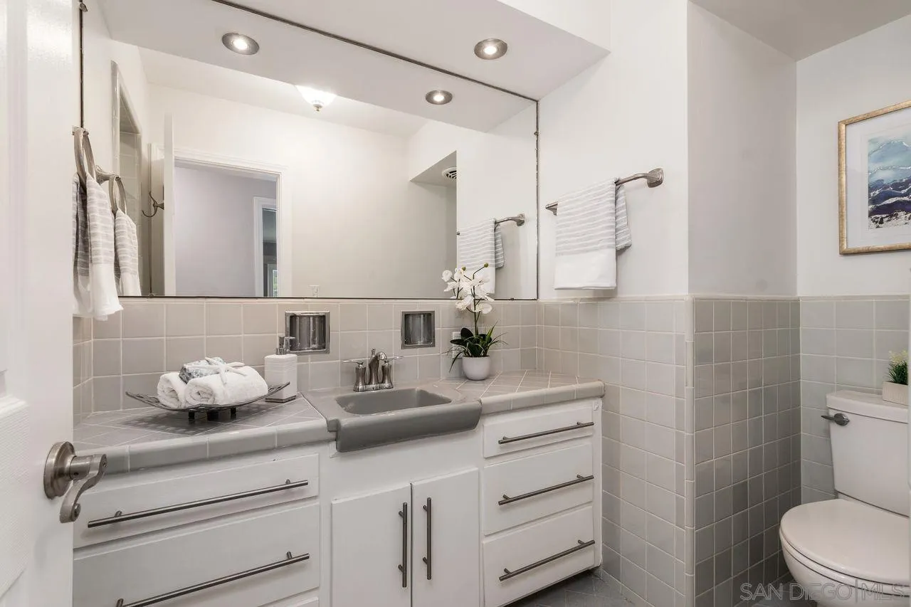 2362 Torrey Pines Road, Unit 33 La Jolla, CA 92037 - Photo 18 of 32 a bathroom with a sink mirror vanity and toilet
