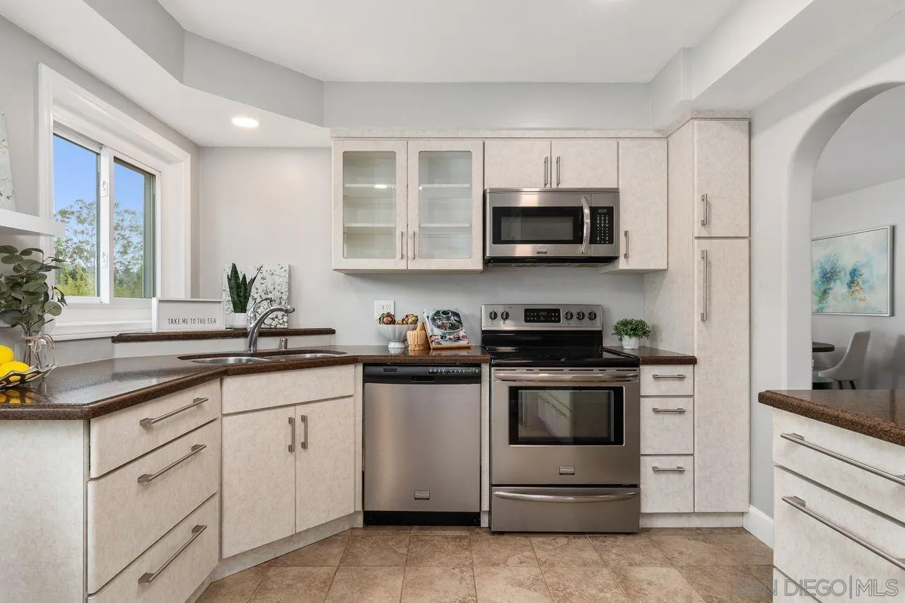 2362 Torrey Pines Road, Unit 33 La Jolla, CA 92037 - Photo 8 of 32 a kitchen with stainless steel appliances granite countertop a stove a sink and a microwave
