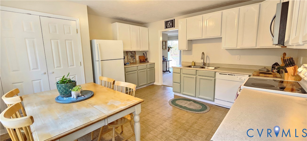 2239 Mantapike Landing Road Stevensville, VA 23161 - Photo 16 of 22 a kitchen with a sink a stove and white cabinets