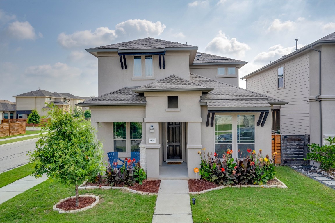 a front view of a house with a garden and plants