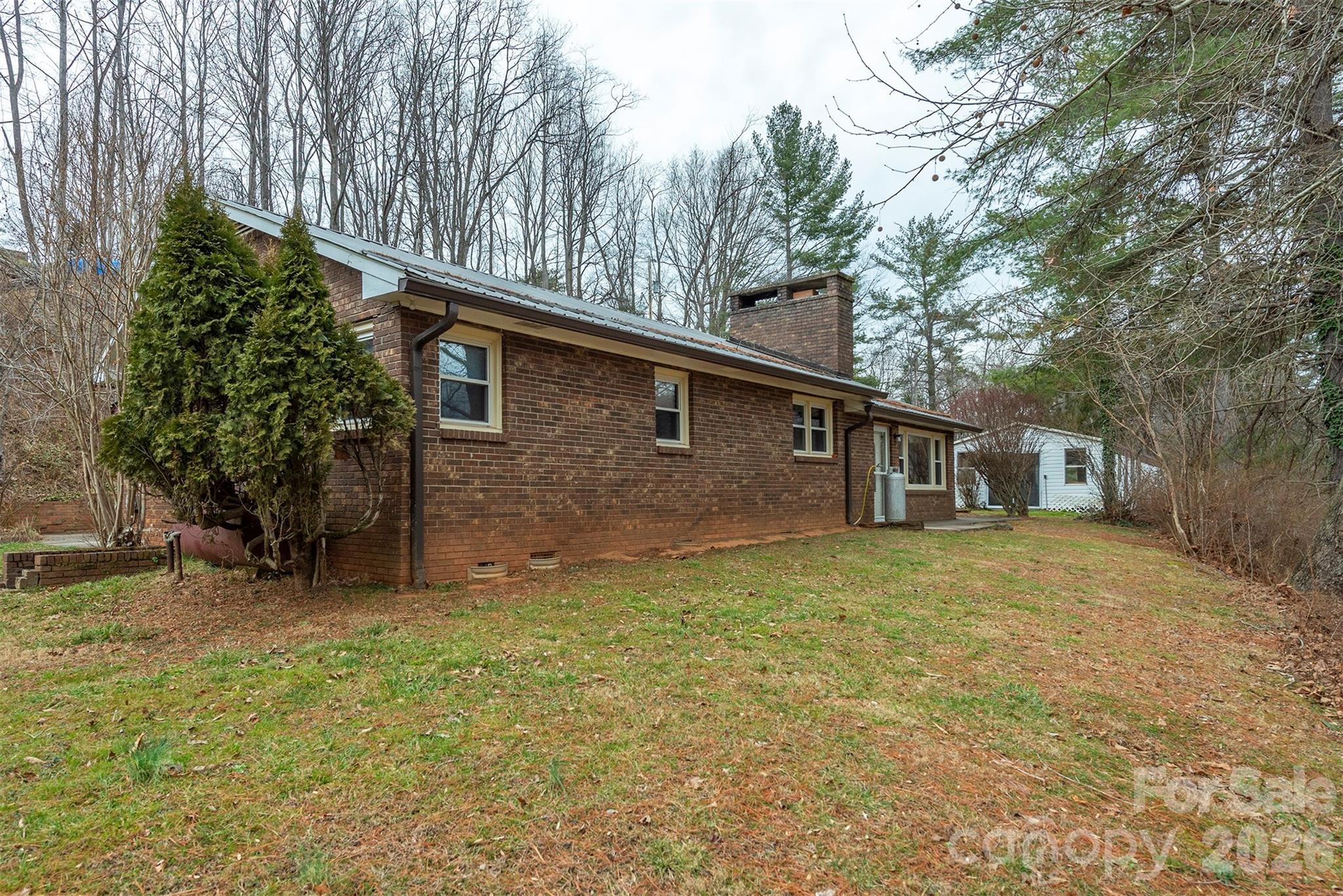 175 River Lane Canton, NC 28716 - Photo 3 of 35 a backyard of a house with large trees and table and chairs