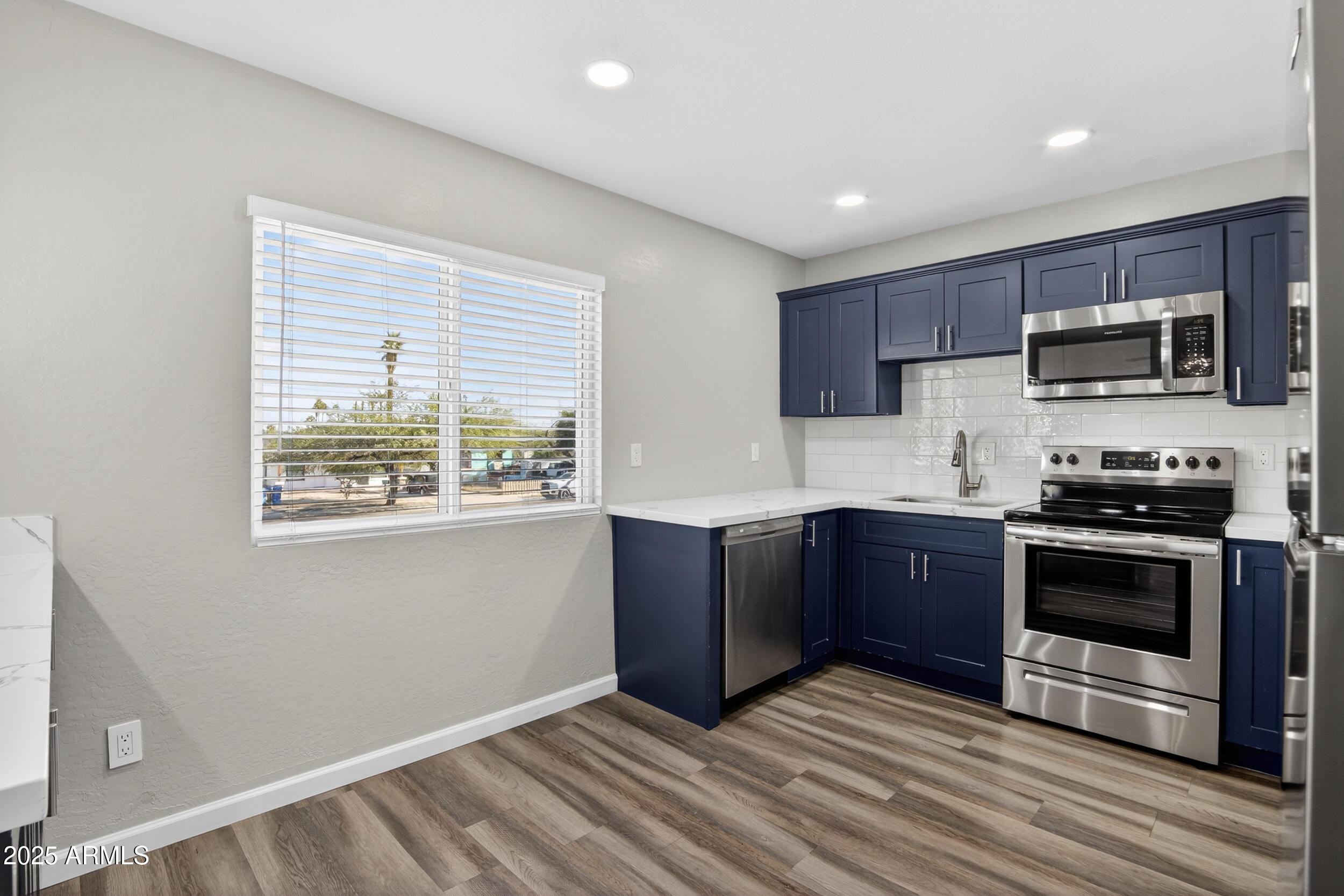 1110 North 10th Street, Unit 2 Phoenix, AZ 85006 - Photo 13 of 22 a kitchen with stainless steel appliances granite countertop a stove a sink and a microwave