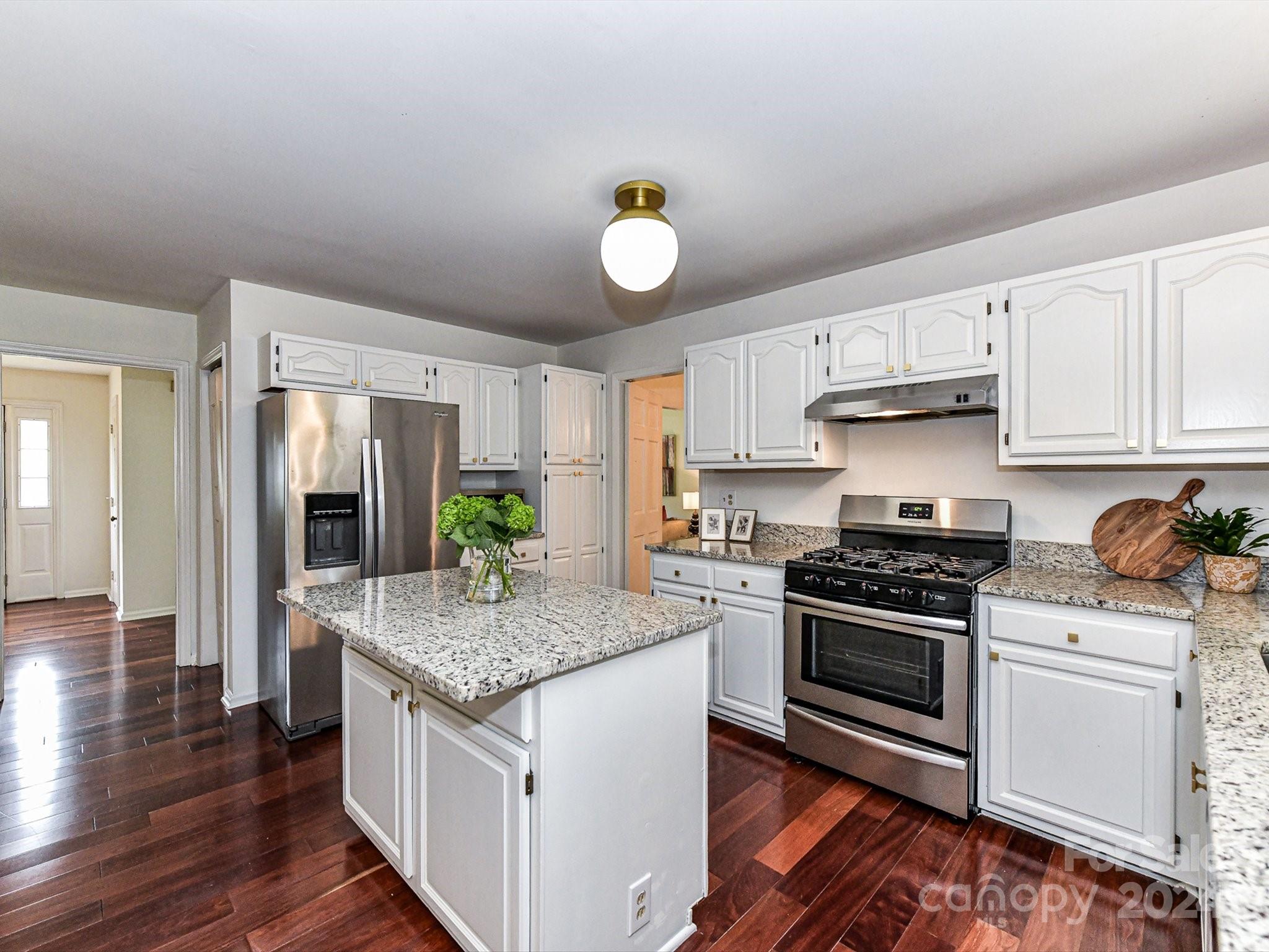717 Fredricksburg Road Matthews, NC 28105 - Photo 16 of 34 a kitchen with granite countertop a sink cabinets stainless steel appliances and wooden floor