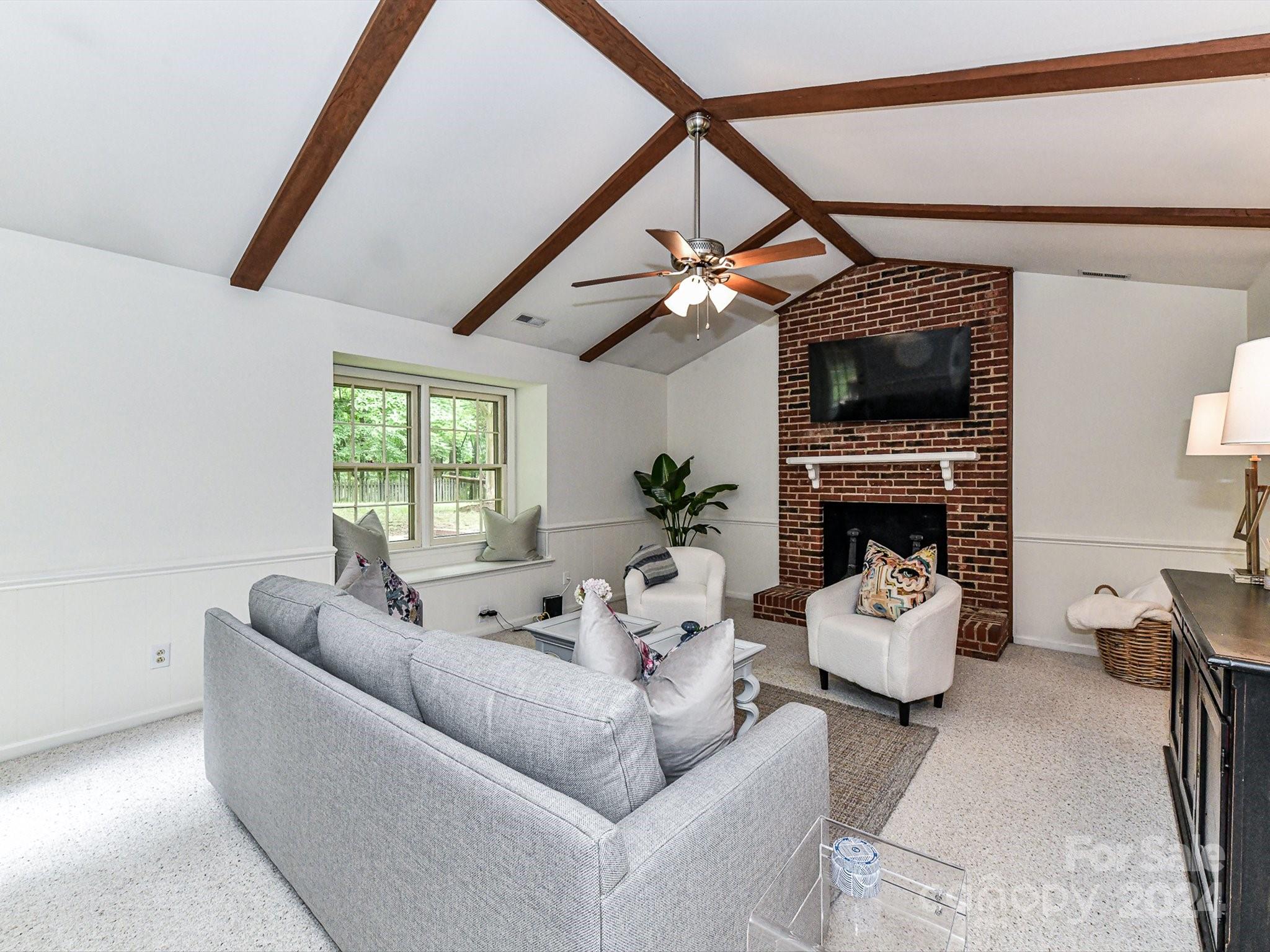 717 Fredricksburg Road Matthews, NC 28105 - Photo 17 of 34 a living room with furniture a fireplace and a flat screen tv
