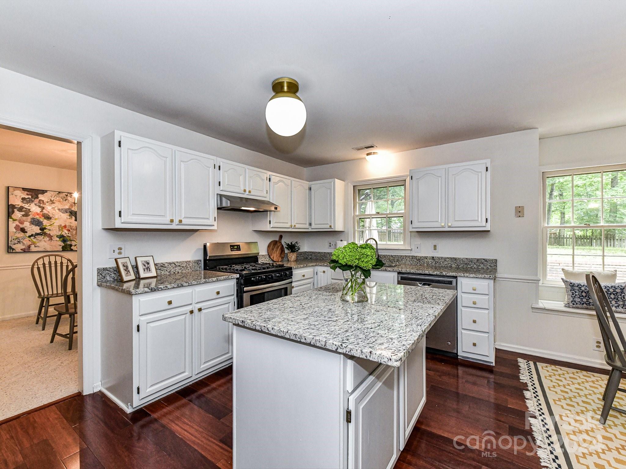 717 Fredricksburg Road Matthews, NC 28105 - Photo 10 of 34 a kitchen with granite countertop stainless steel appliances a stove top oven a sink a counter space and cabinets