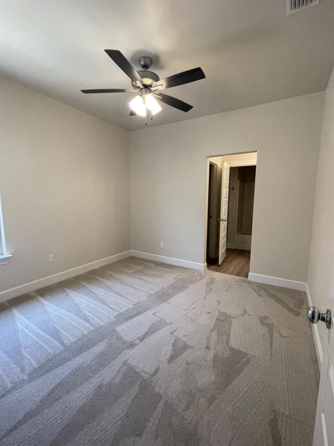 5718 119th Lubbock, TX 79424 - Photo 14 of 17 a view of an empty room with wooden floor and a ceiling fan
