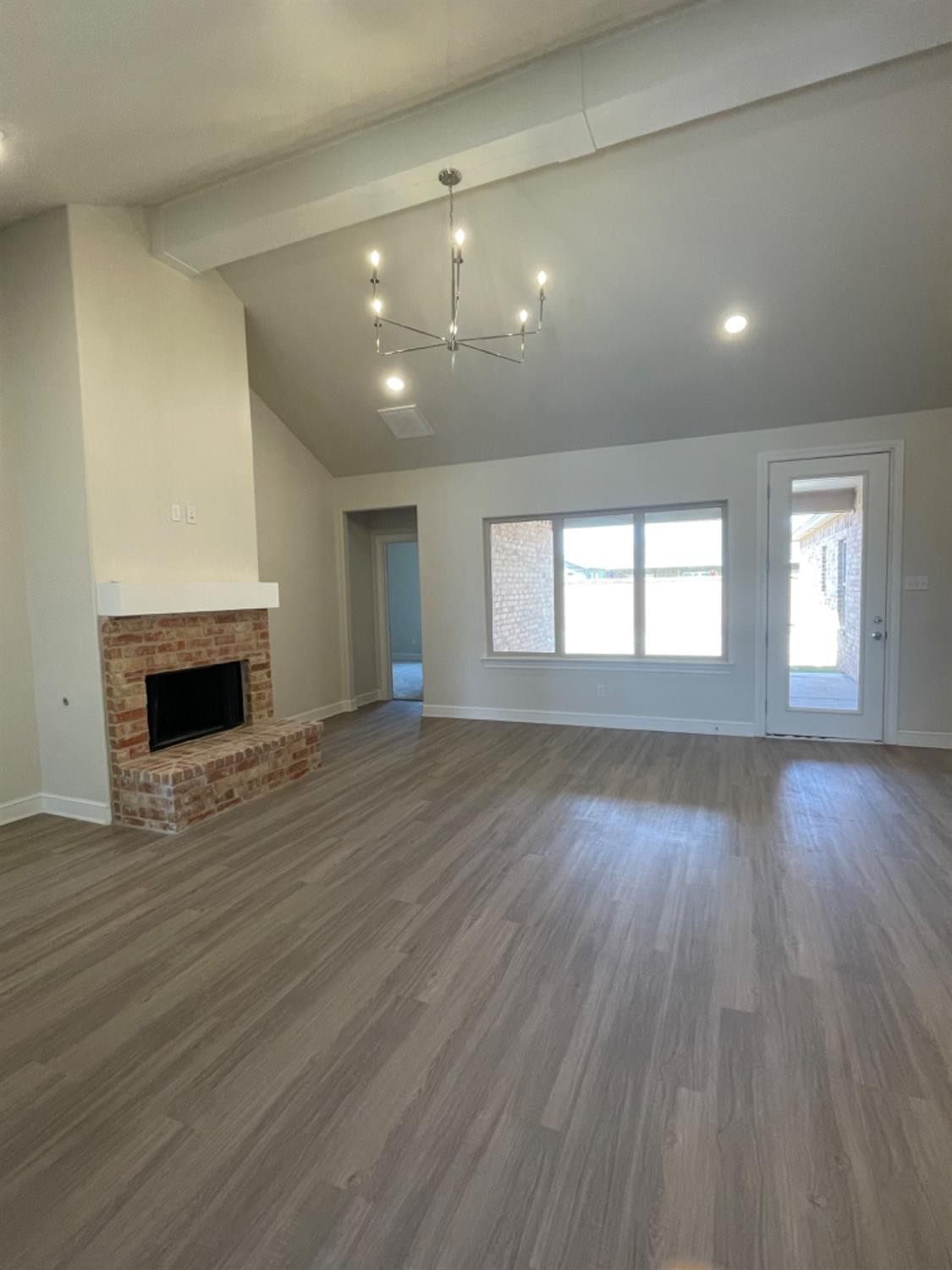 5718 119th Lubbock, TX 79424 - Photo 4 of 17 an empty room with wooden floor and fireplace