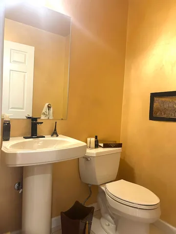 a bathroom with a toilet a sink and mirror