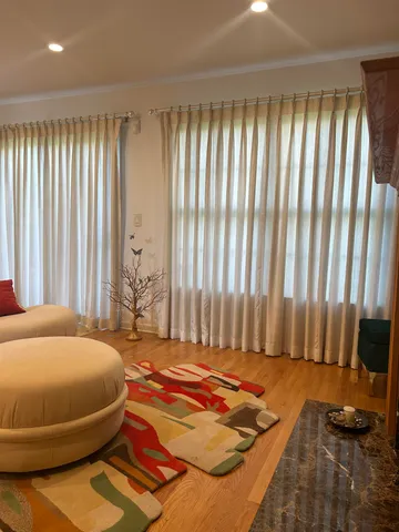 a bedroom with a bed and large windows