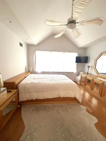 a large bed sitting in a room next to a window