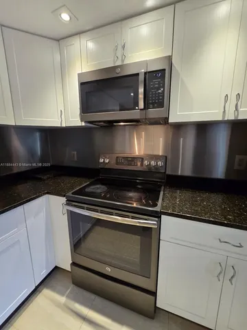 a kitchen with stainless steel appliances granite countertop a stove and a microwave