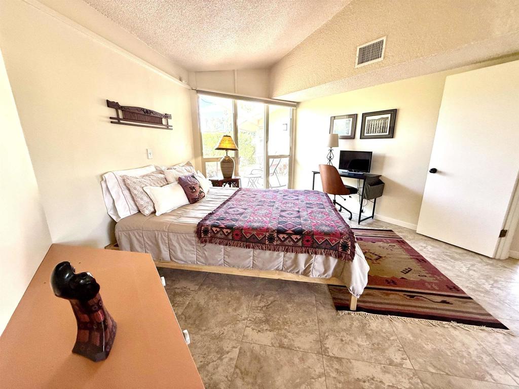 37800 Da Vall Drive, Unit 10 Rancho Mirage, CA 92270 - Photo 21 of 31 a bedroom with a bed and wooden floor