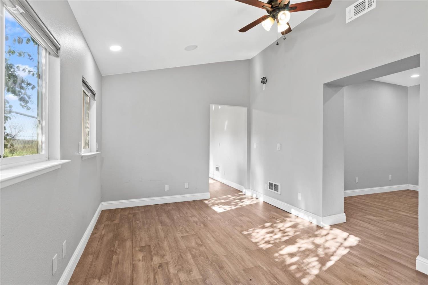 8335 Bailey Road Yuba City, CA 95993 - Photo 7 of 56 a view of a big room with wooden floor and a chandelier fan