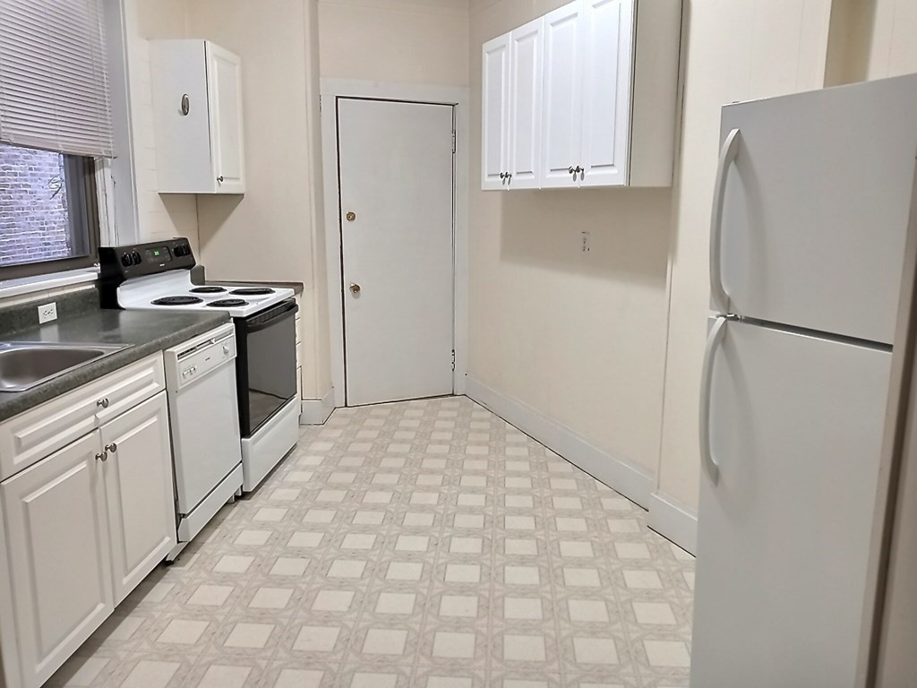 a kitchen with a refrigerator sink stove and cabinets