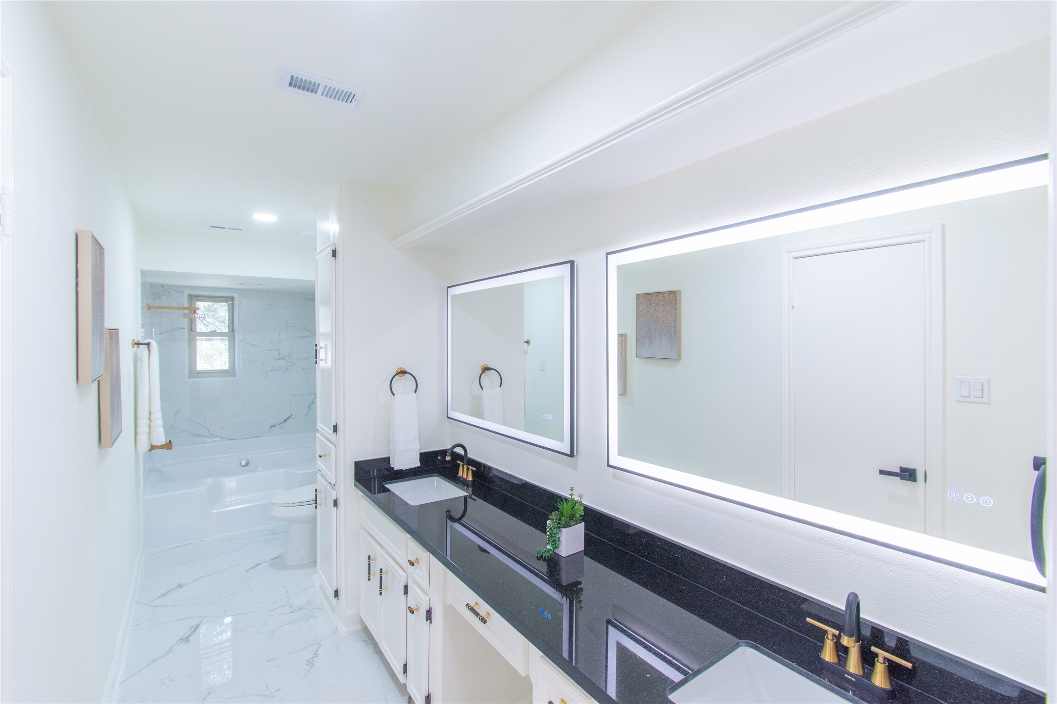 727 Bunker Hill Road, Unit 43 Houston, TX 77024 - Photo 32 of 36 a spacious bathroom with a granite countertop sink a mirror and a bathtub