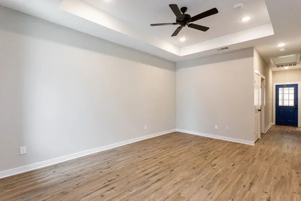 an empty room with wooden floor and windows