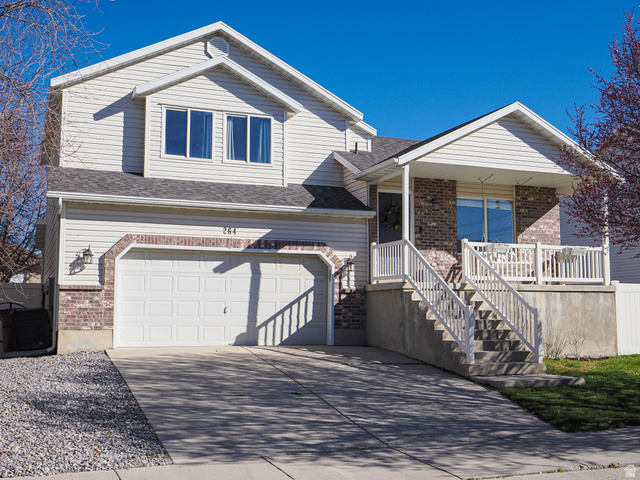 264 West 13165 South Draper, UT 84020 - Photo 1 of 1 View of front of house with an attached garage, concrete driveway, covered porch, a shingled roof, and brick siding