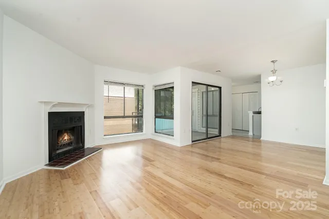 a view of empty room with wooden floor and fireplace