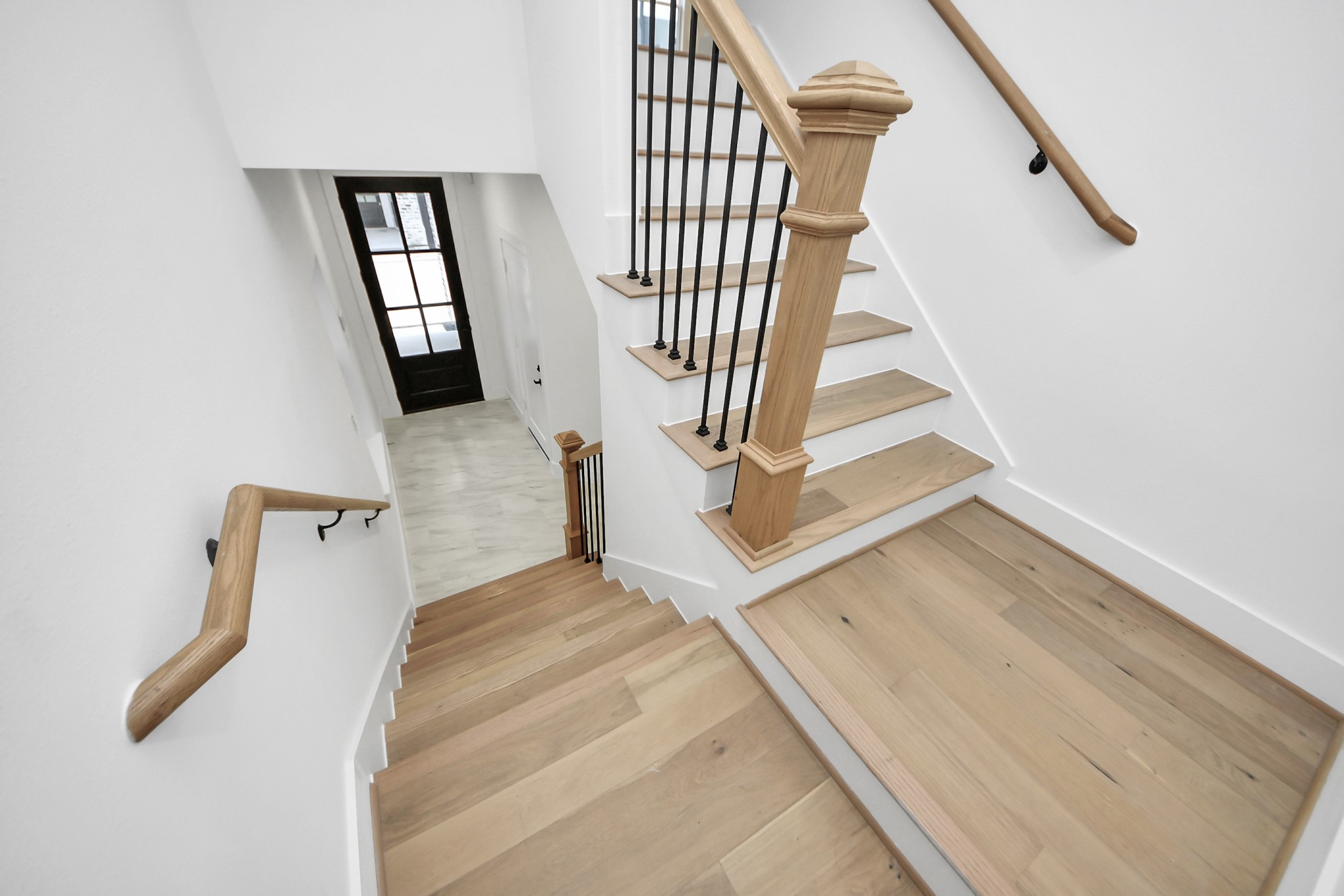 723 Marcella Street, Unit B Houston, TX 77091 - Photo 5 of 22 As you step into your bright, modern entryway with a staircase, you are greeted with stone tiled flooring, wooden custom handrails with white risers, leading to the upper second level. There's a glimpse into your well-lit secondary room with private en-suite bathroom.