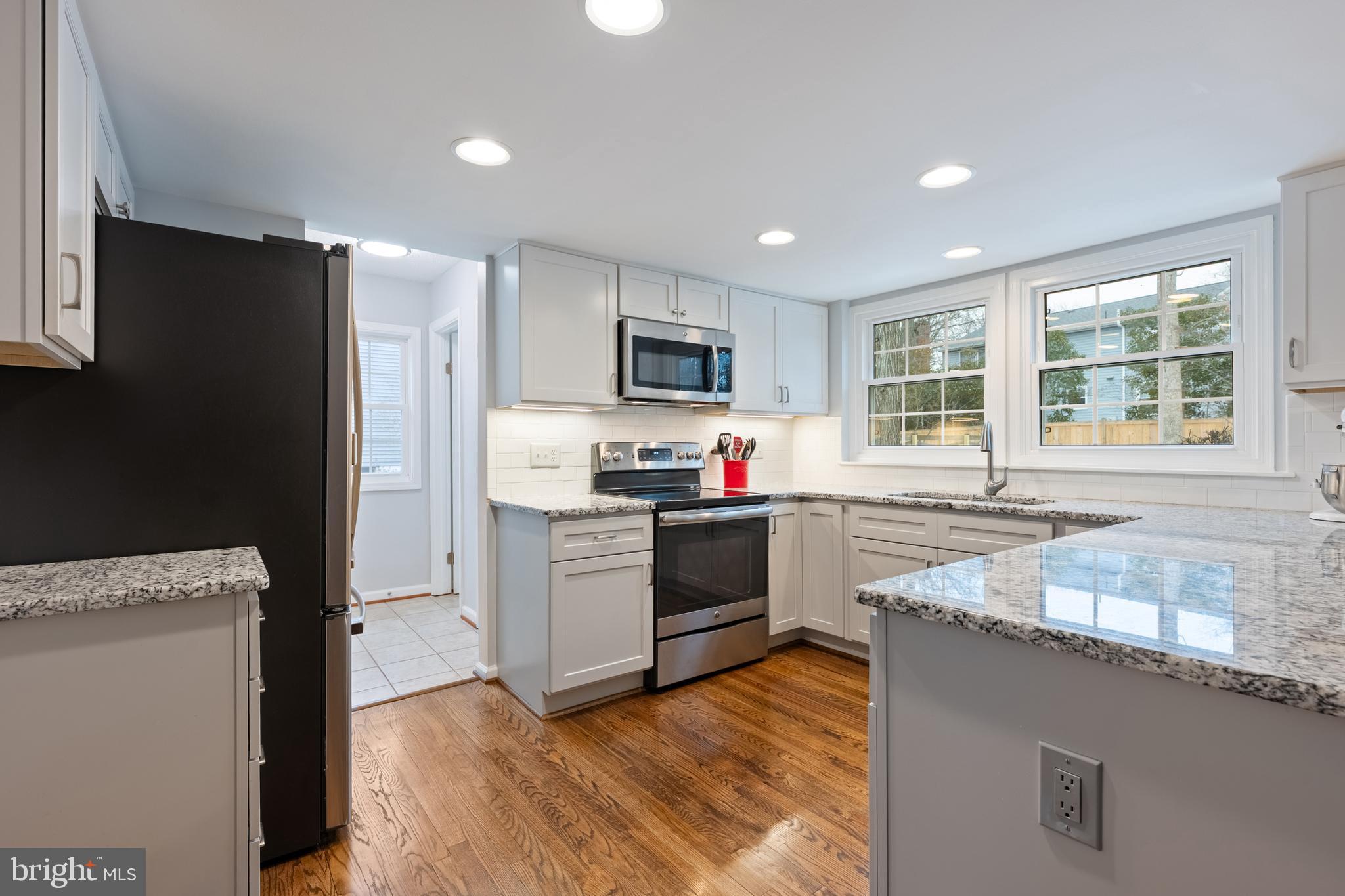 1374 Rock Chapel Road Herndon, VA 20170 - Photo 9 of 38 a kitchen with granite countertop a refrigerator and a stove top oven